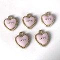 Detalle de colgantes de corazón en esmalte rosa con grabado Love y borde dorado - Corazón Rosa