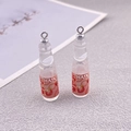 Macro shot of 3D resin Ramune bottle charms with realistic red labels for DIY jewelry - Transparent Bottle