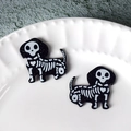 Close-up of glitter black dachshund skeleton charms with heart rib detail for DIY jewelry - Skull Dog