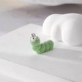 Macro detail of a fuzzy green caterpillar charm with soft flocking and metal ring - Caterpillar