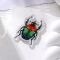 Detailed macro of colorful acrylic beetle pendants with glitter finish and pre-drilled holes - Red Head Green Back Beetle