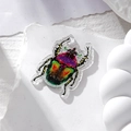 Close-up of acrylic ladybug pendants with colorful glitter finish for DIY jewelry - Purple Head Green Back Beetle
