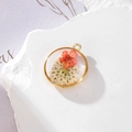 Pendente tondo dorato con margherita essiccata arancione e resina trasparente - 16 GH59