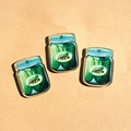 Detailed view of three acrylic pickle jar pendants with green labels and hanging holes - Can-Shaped / Pickle Jar