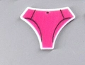 Close-up of hot pink thong-shaped acrylic pendant with hanging hole and black trim detail - Triangle Briefs