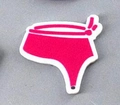 Macro view of a hot pink bikini bottom acrylic charm with bow detail for DIY jewelry - Bikini