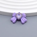 Detalle de colgante de lazo morado con ópalo de corazón y diamantes de imitación brillantes - Lazo Púrpura
