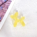 Translucent yellow resin balloon dog charm with metal loop on white texture - Yellow