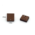 Detail view of 1.5cm square walnut wood earring studs with metal pins and hole design - Square