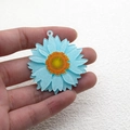 Macro-opname van een lichtblauwe madeliefjesbedel met glitters voor doe-het-zelf sieraden - 3D Blauw
