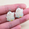 Close-up of translucent white ghost charms with colorful star sequins and silver loops - Ghost