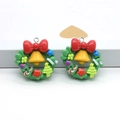Macro detail of Christmas wreath charms with red bows and tiny bells for DIY jewelry - Christmas Wreath
