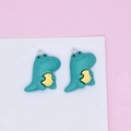 Close-up of green resin dinosaur charms with silver jump rings for DIY jewelry projects - Crocodile