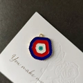 Λεπτομέρεια macro από το μενταγιόν Evil Eye με κυματιστή χρυσή άκρη σε κόκκινο και μπλε - Σκούρο Μπλε Ακανόνιστο
