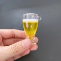 Makroaufnahme von Miniatur-Bierkrug-Anhänger aus Harz mit Schaum und feinen Blasen - Hohes Pilsner Glas