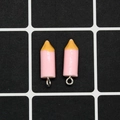 Close-up of pink pencil-shaped resin charms with silver metal rings for DIY jewelry - Pink Crayon