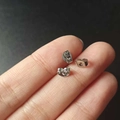 Set of three small silver butterfly earring backs shown on a fingertip for size - Stainless Steel Earring Backs