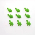 Macro-detail van negen groene schildpadhangers van hars voor DIY-sieraden maken - Schildpad
