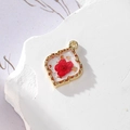 Alloy gold foil resin pendant featuring a real red dried flower in a clover frame - Red Flower