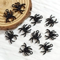 Detailed view of ten black spider charms with top loops for DIY jewelry making - Spider