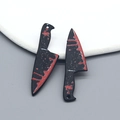Close-up of blood-splattered cleaver pendants for Halloween jewelry making - Triangular Fruit Knife Style