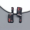 Detailed view of Halloween cleaver pendants with red splatter for DIY jewelry making - Cleaver