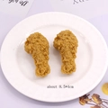 Detail shot of two realistic fried chicken pendants with sizes on a white ceramic plate - Fried Chicken Drumstick Style (K76)