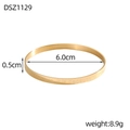 Dettaglio macro di un elegante bracciale dorato con scritte ispiratrici incise sul metallo - Stile Inciso Largo Oro (DSZ1129)