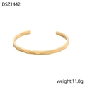 Detalle de la textura geométrica facetada en un brazalete abierto con acabado dorado - Estilo de Corte Geométrico Dorado (DSZ1442)