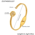 Dettaglio del bracciale rigido aperto in acciaio dorato con fiore cavo e zircone - Gold Bangle (Z537)