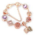 Gros plan d'un bracelet rose doré avec cristaux violets et breloques en pierre rose - Style 9 (Or rose-Feuille d'étoile violette)