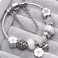Bracelet à breloques DIY avec perles en verre blanc et pendentifs fleurs dans un écrin - Style Blanc Élégant