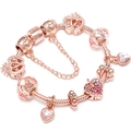 Bracelet à breloques en or rose avec pendentifs cœur et couronne sur fond blanc - Style Romantique Couronne Feuille