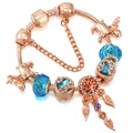Detailed close-up of rose gold dreamcatcher bracelet with blue crystals and leaf charms - 16cm / Blue Tree of Life Style (#2)