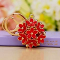 Golden keychain featuring a red floral globe charm with 3D hollow daisy patterns - Red