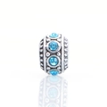 Macro view of silver charm bead with sky blue crystal and textured relief detail - Light Blue
