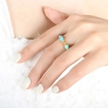 Anello dorato in stile egiziano con pietre scarabeo blu sulla mano della donna - US 6 / Anello (A492) / Oro