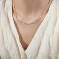 Collar de cadena dorada con cuentas de colores en modelo con blusa de textura blanca - Collar Multicolor / Dorado