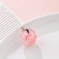 Luminous round resin pendant featuring pink clouds and a bird with a golden bail - Aesthetic Pink Bird (4#)