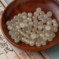 Translucent milky white beads in a wooden bowl for DIY jewelry making and necklaces - Cream