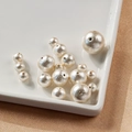 Makroaufnahme verschiedener cremeweißer Baumwollperlen mit Textur für DIY-Schmuckherstellung - 8mm / Beige