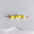 Vue macro de deux perles en forme d'os jaune clair sur des épingles à bijoux dorées - Light jaune