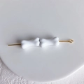 Détail de perles blanches en forme d'os sur une épingle dorée pour bijoux DIY - Blanc
