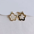 Detailed macro view of gold-plated flower charms with white resin on textured fabric - Cream White Flower (4)