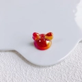 Detail view of bow-shaped acrylic bead with red-orange gradient and metallic luster - Iridescent Red Orange