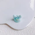 Close-up of a pearlescent light blue acrylic bow charm for DIY jewelry and phone cases - Aurora Light Blue