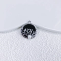 Macro view of silver heart pendant with black enamel, pearl, and coral branch detail - Silver Round Coral Black Base (3)