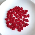 Macro detail of red hollow heart beads with glazed finish for DIY jewelry making - Red