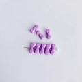 Dettaglio macro di otto ciondoli a fiocco viola pastello e spilla per gioielli fai-da-te - Viola