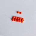 Detailaufnahme hellorangefarbener Schleifenperlen aus Harz mit glänzender Oberfläche - Orange